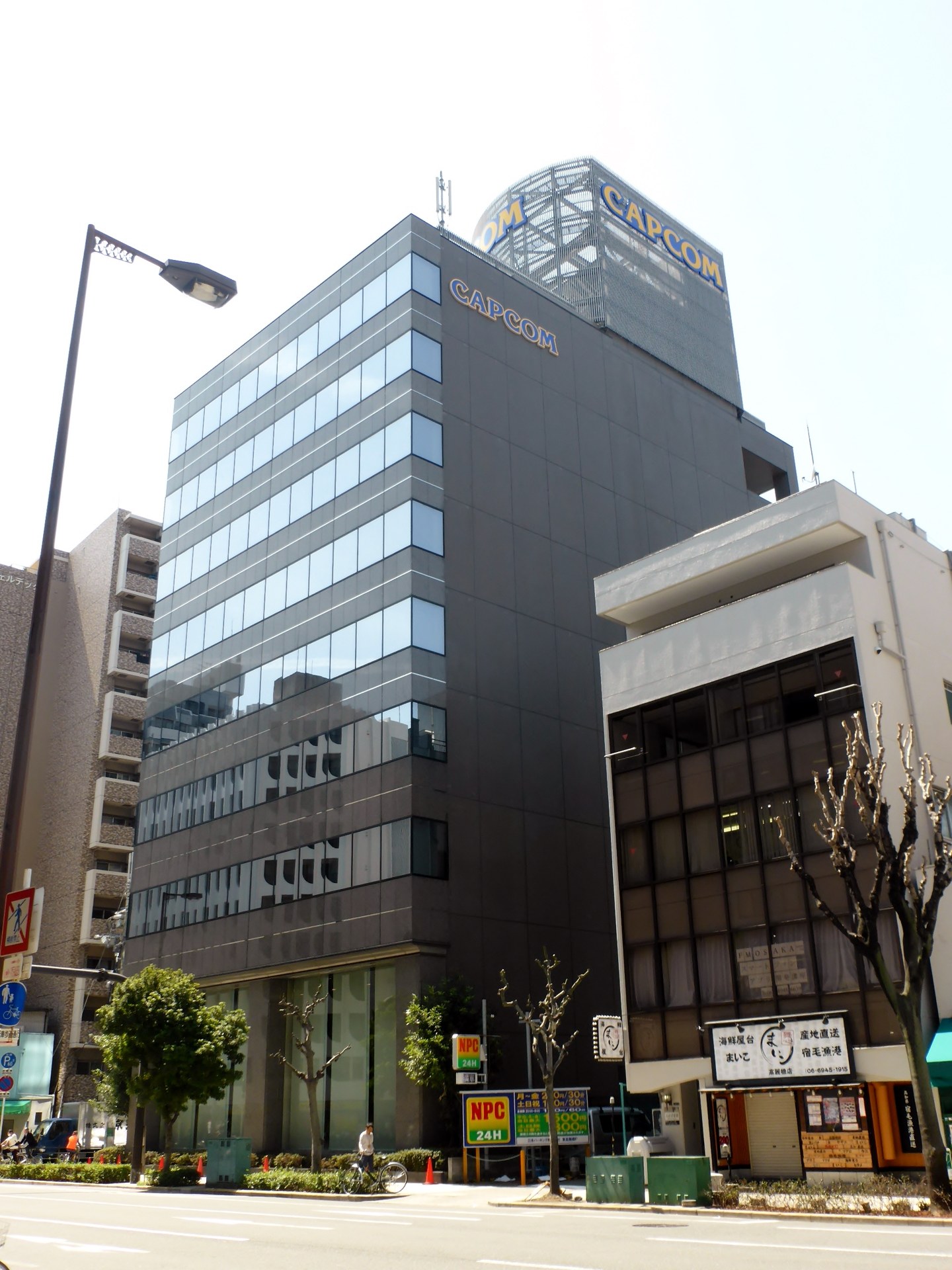 示意圖：遊戲公司大會現場，大螢幕顯示遊戲引擎畫面（AI 生成示意圖）