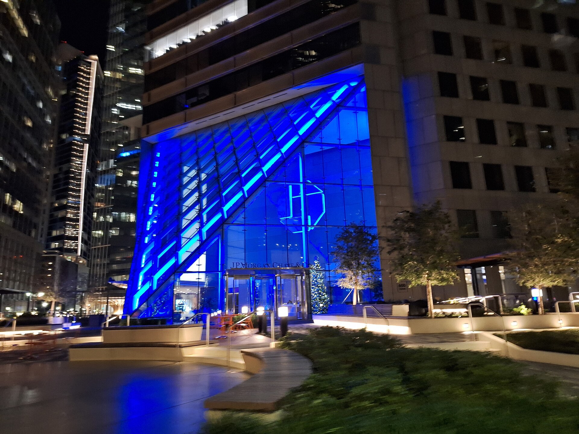 一間大型銀行辦公室內，數名財富顧問喺枱前工作，枱上電腦螢幕顯示數據與文件，象徵 AI 處理大量入門同研究文件嘅場景。